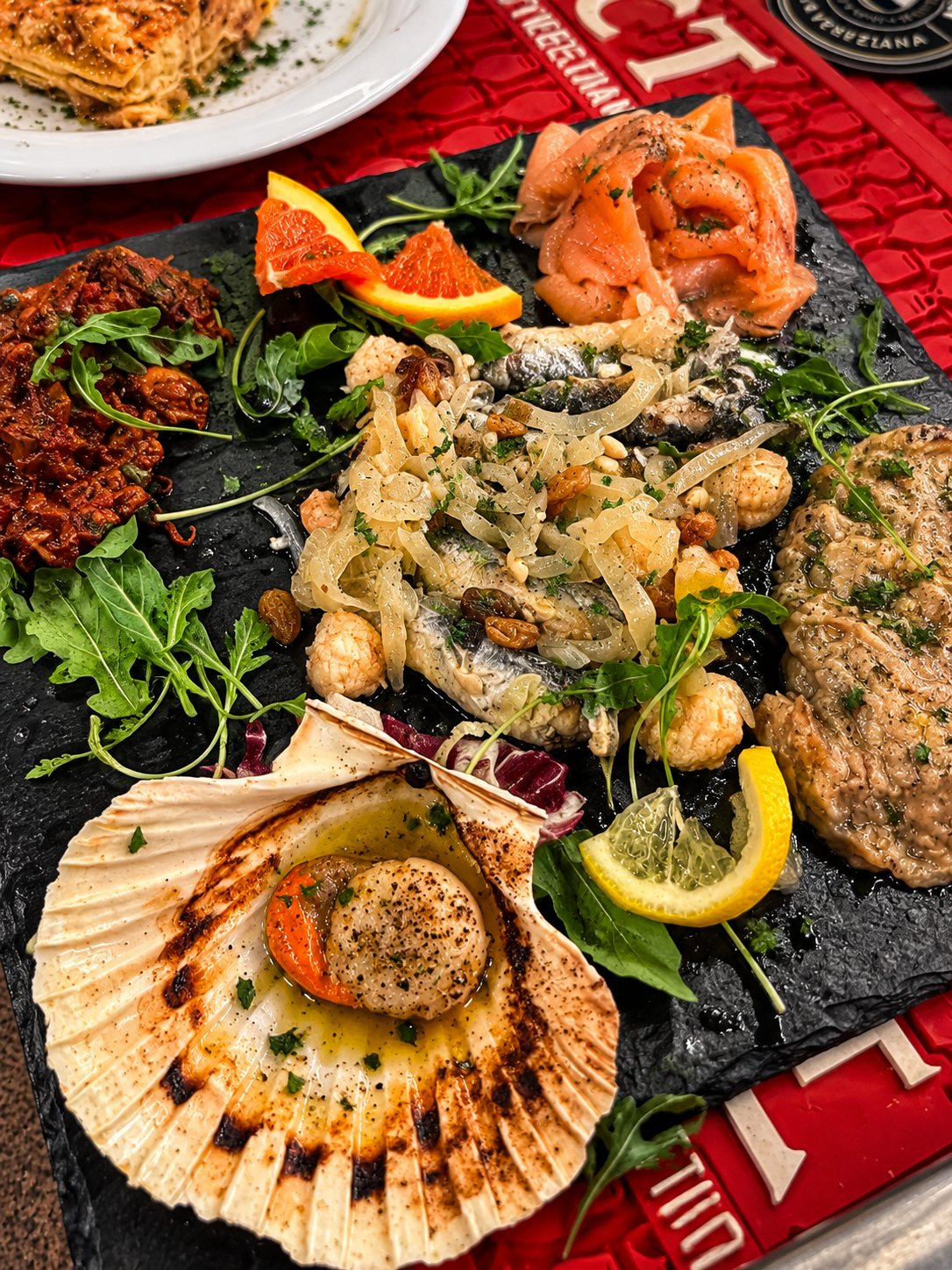 Tagliere di cicchetti veneziani: salmone, sarde in saor, capasanta gratinata e carne salada